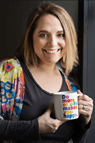A headshot of a woman holding a mug