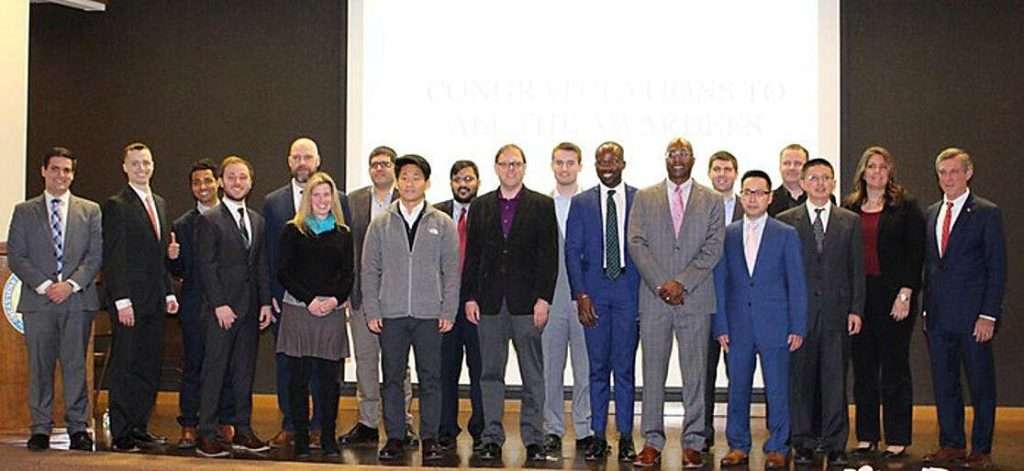 A large group of people in business attire standing on a stage.