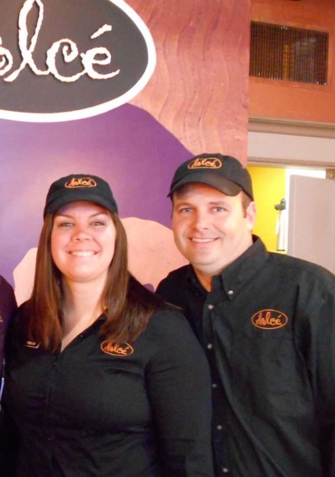 A man and a woman wearing black shirts and black caps