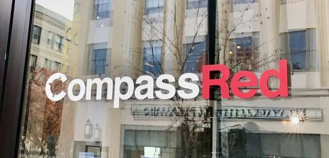A window with a sign reading Compass Red