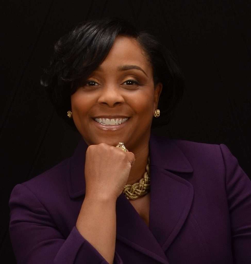 Headshot of a woman in a purple jacket