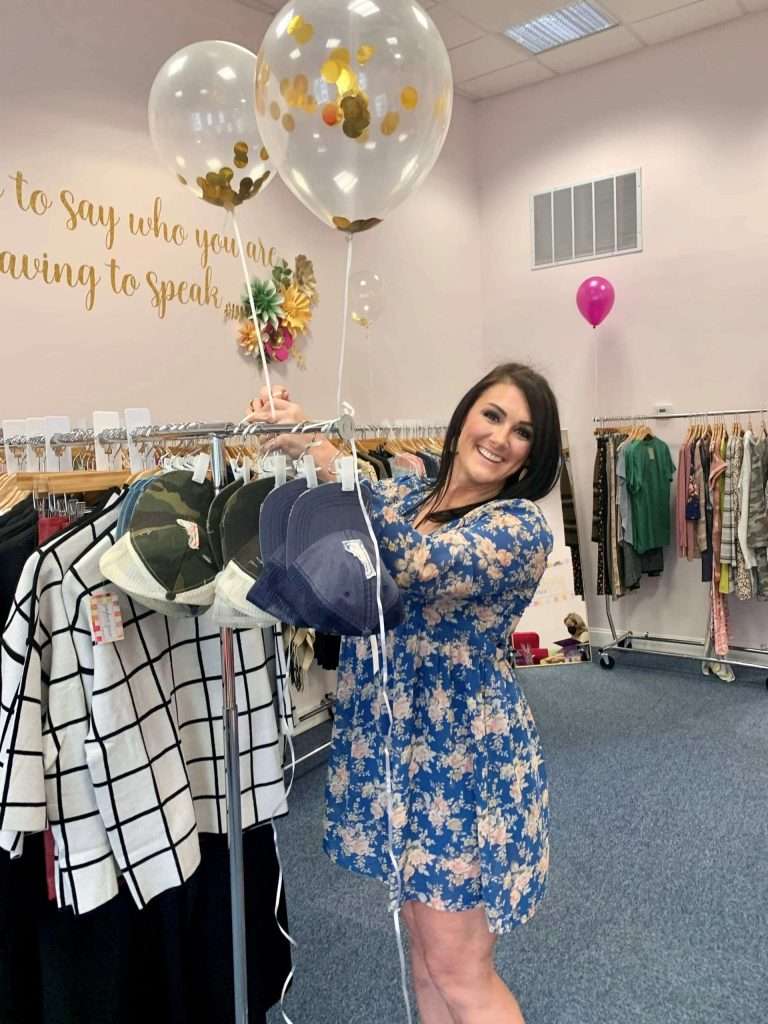 A lady in a blue dress shopping at a clothing store.