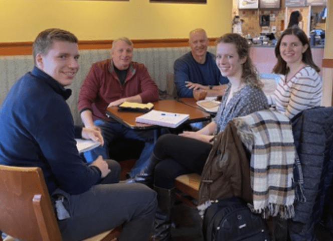 A group of people having a discussion in a restaurant