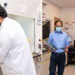 Three men working in a lab wearing face masks
