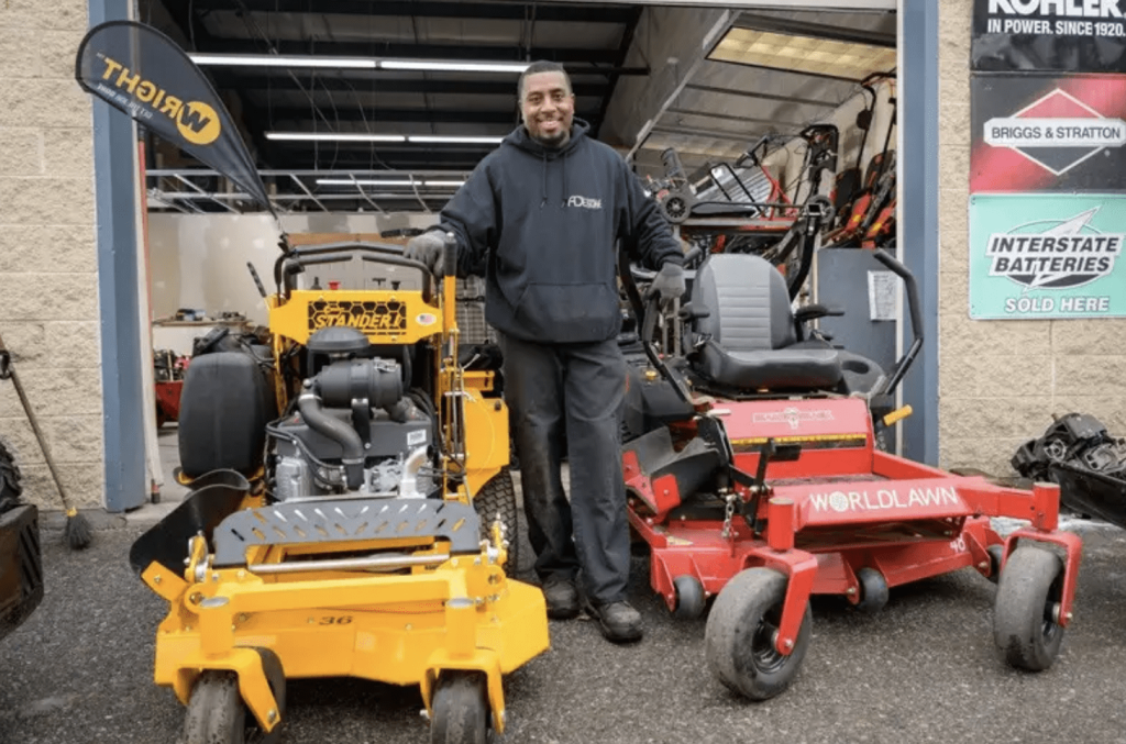 A man standing in a small engine repair shop