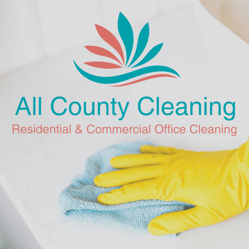 A hand in a yellow glove cleaning a surface with a blue towel.