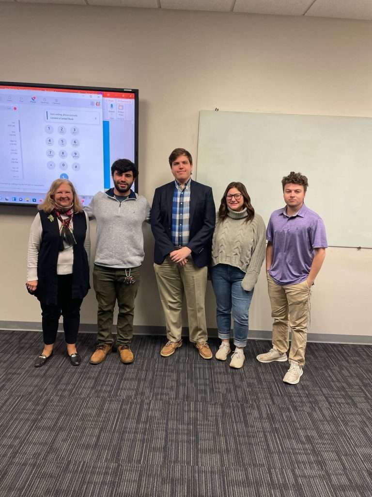 Delaware SBDC advisor standing with UD students