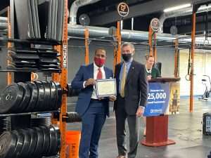 Two men in a professional attire receiving an award at the EDGE grant event