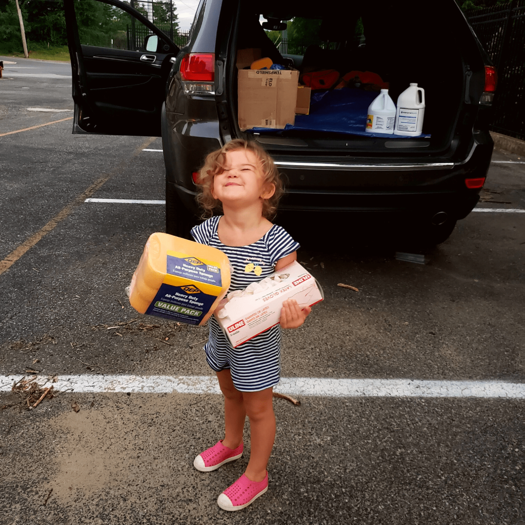 A photo of a little girl holding supplies