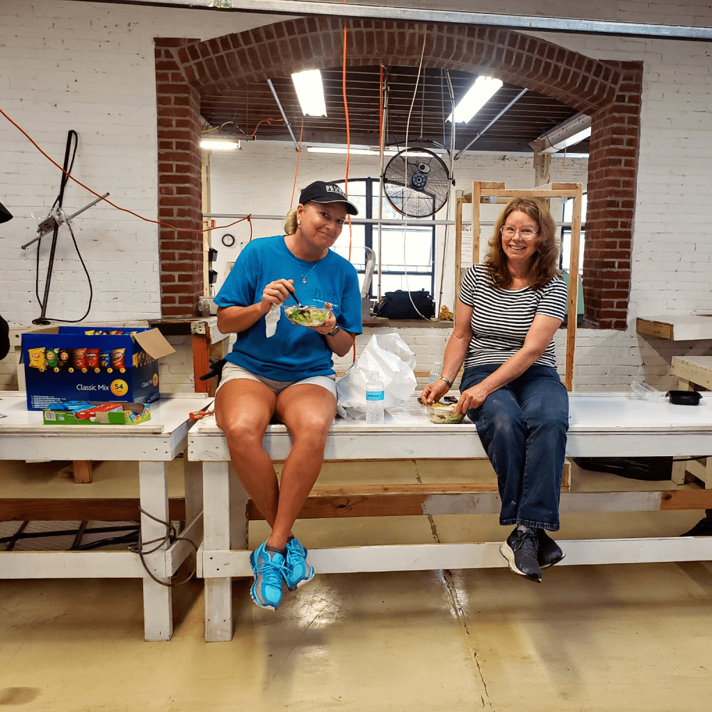 Photo of two ladies sitting on a table eating lunch.