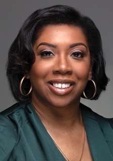 A headshot of a woman in professional attire