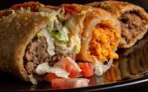 Three different types of burritos on a plate.