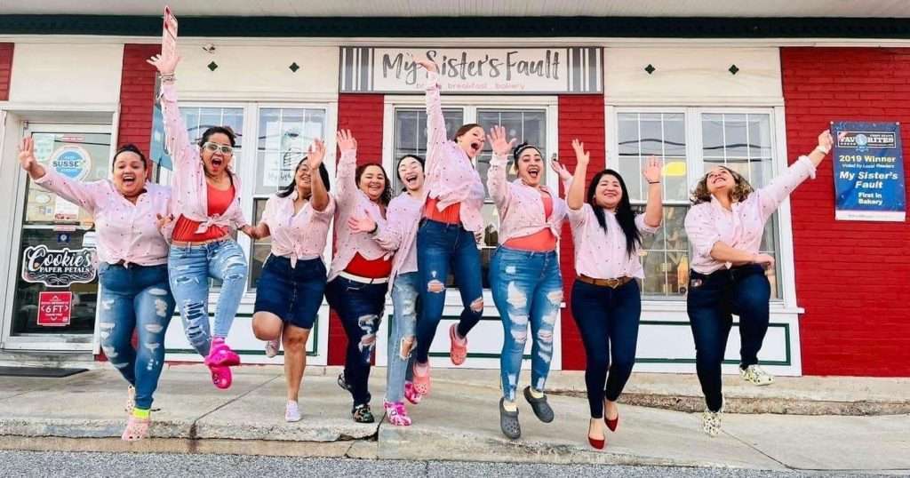 A group of ladies in pink shirts celebrating.