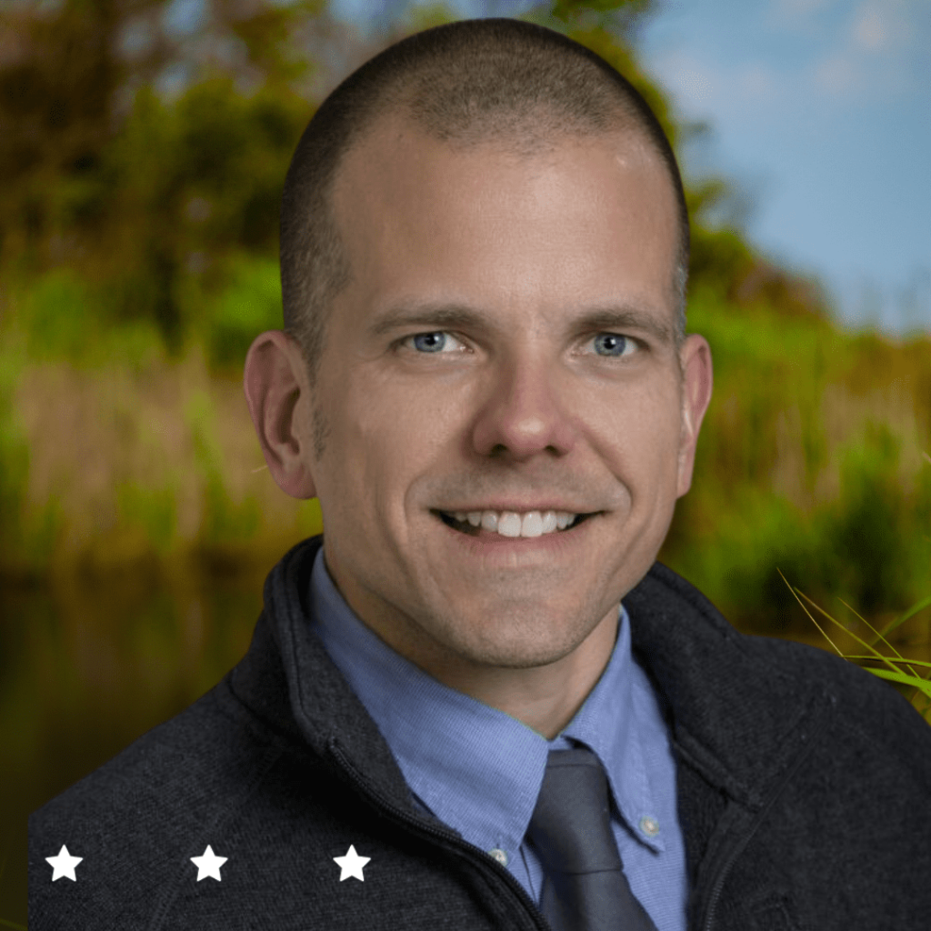 A headshot of a man in a professional attire