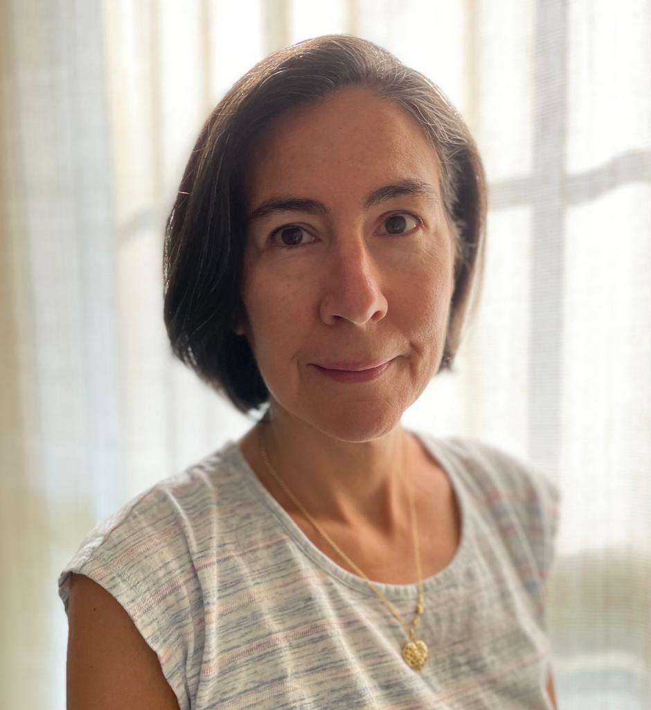 A headshot of a woman in a white shirt