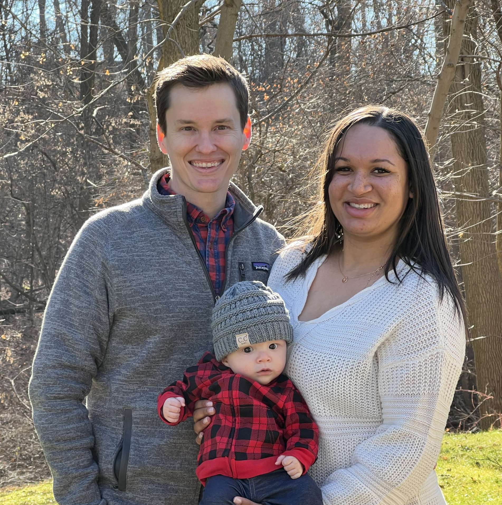 A happy couple holding a baby.