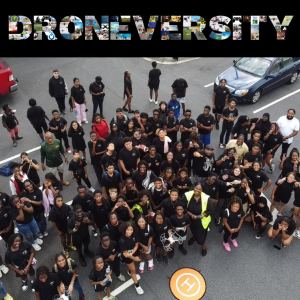 A crowd in black shirts looking up.