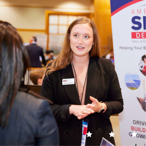 Delaware SBDC staff in professional attire speaking to a client at an event