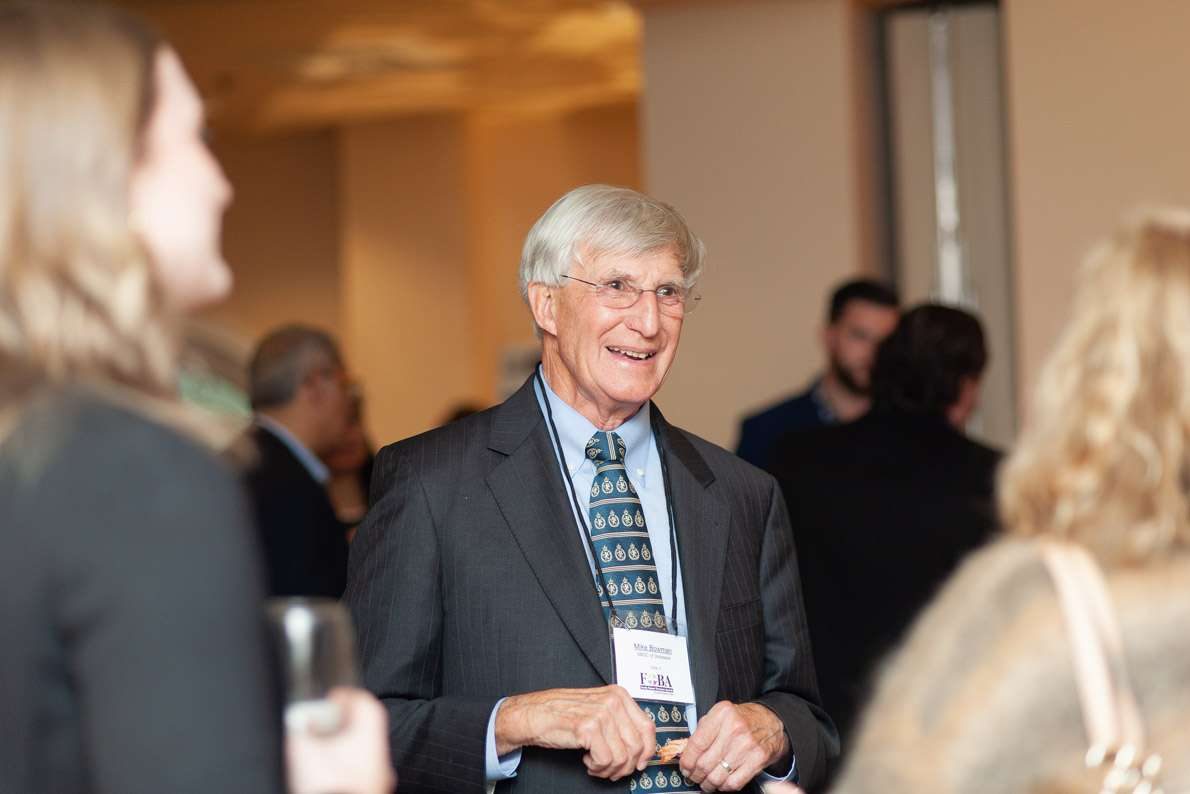 A man in professional attire smiling