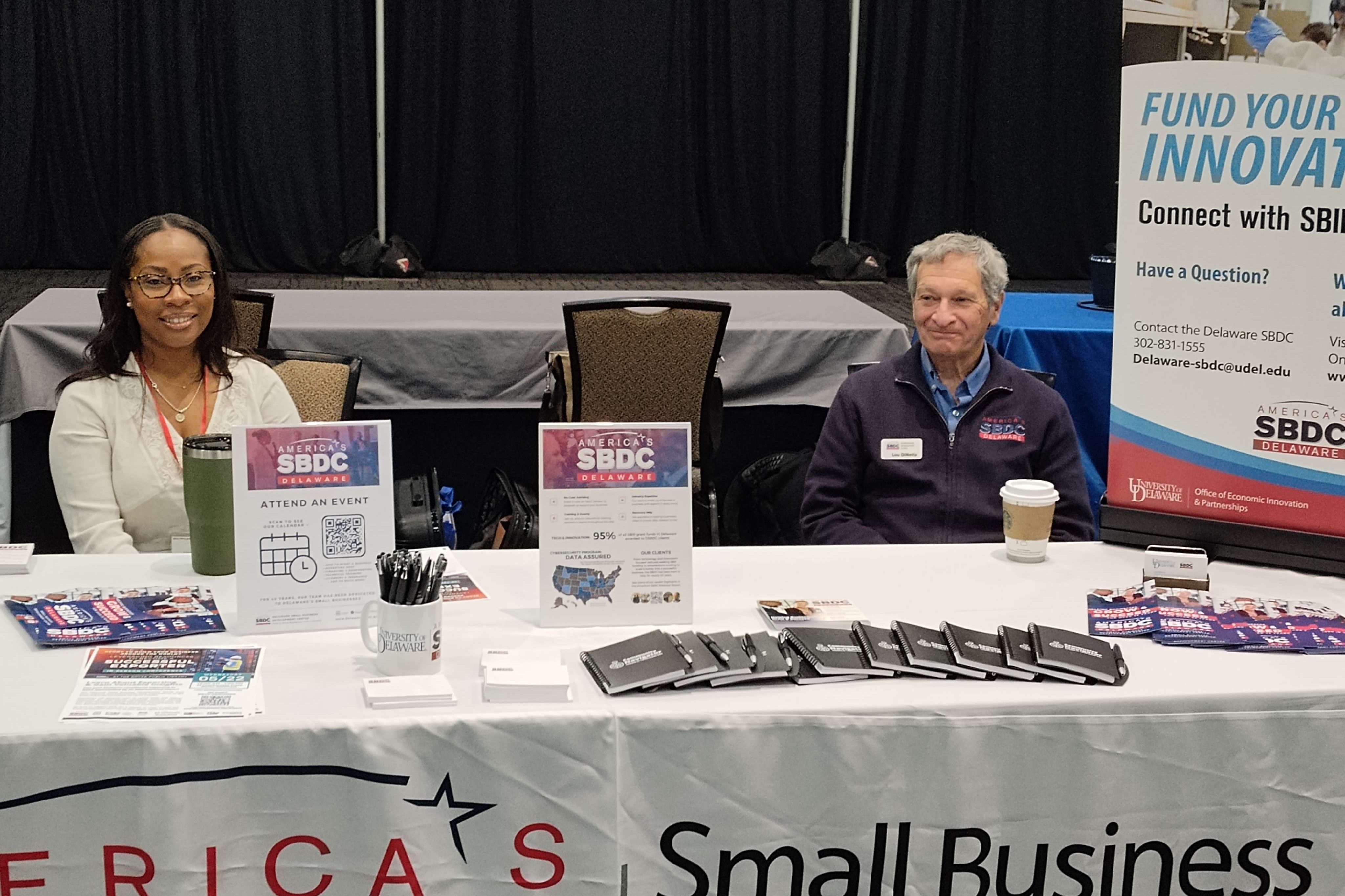 Delaware business advisor sitting at the SBDC tabling event with souvenirs.