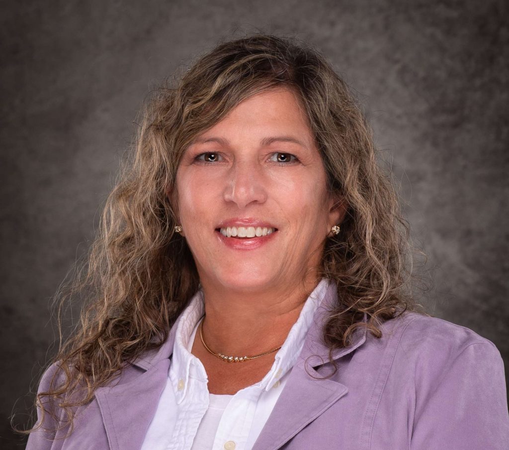 A professional headshot of a woman in business attire.