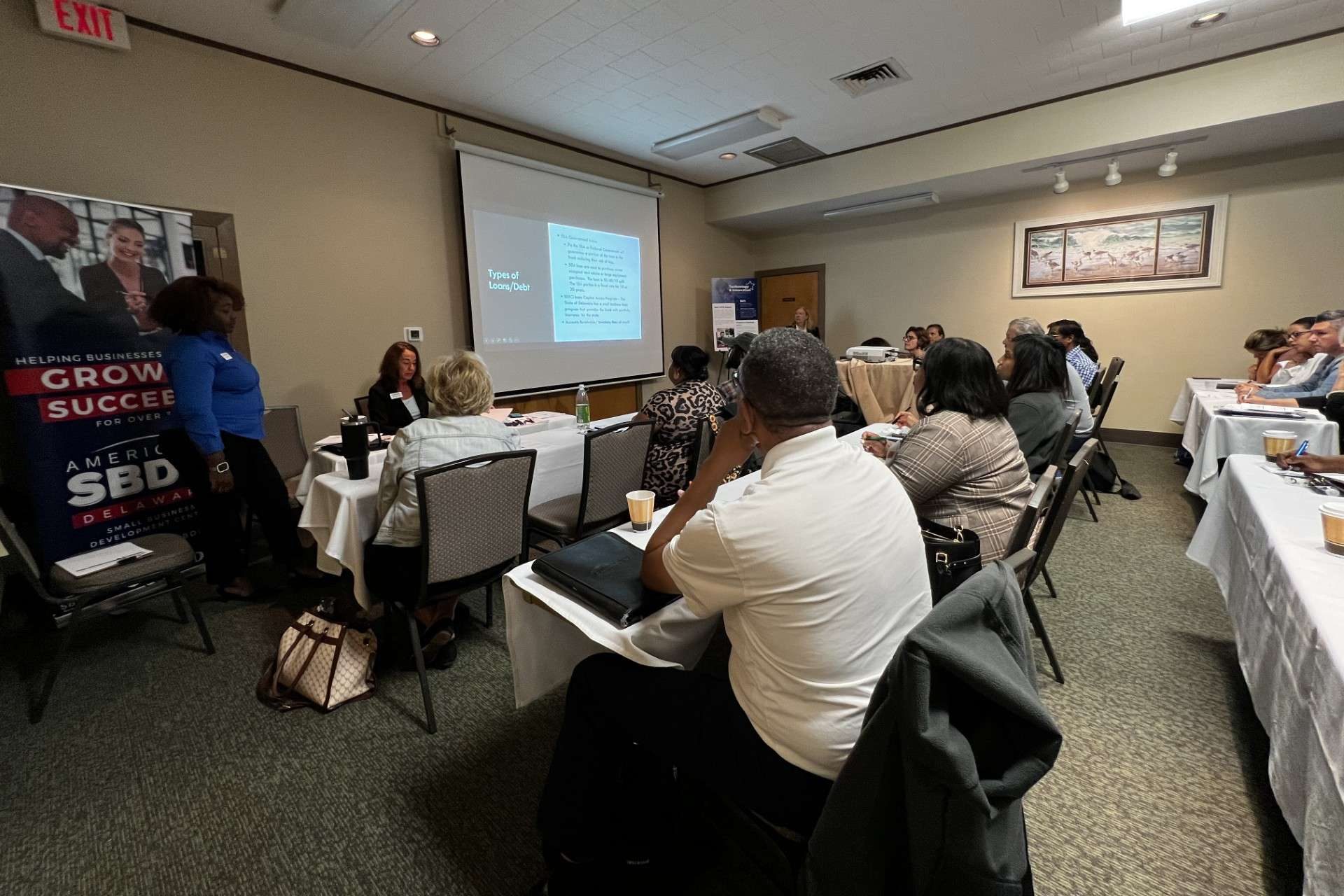 A group of people in a room listening to a presentation