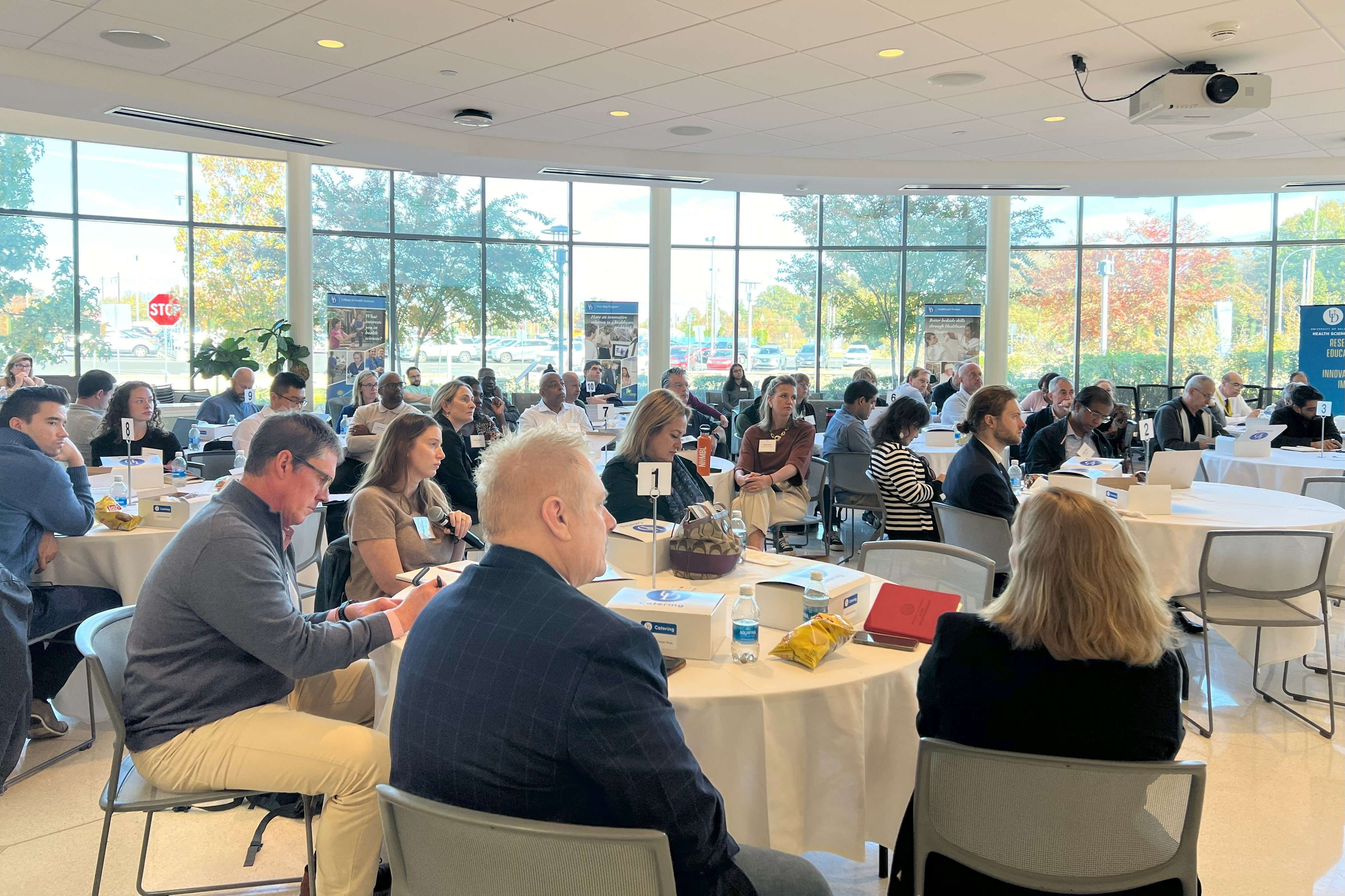 A group of people sitting at a round table at an event.