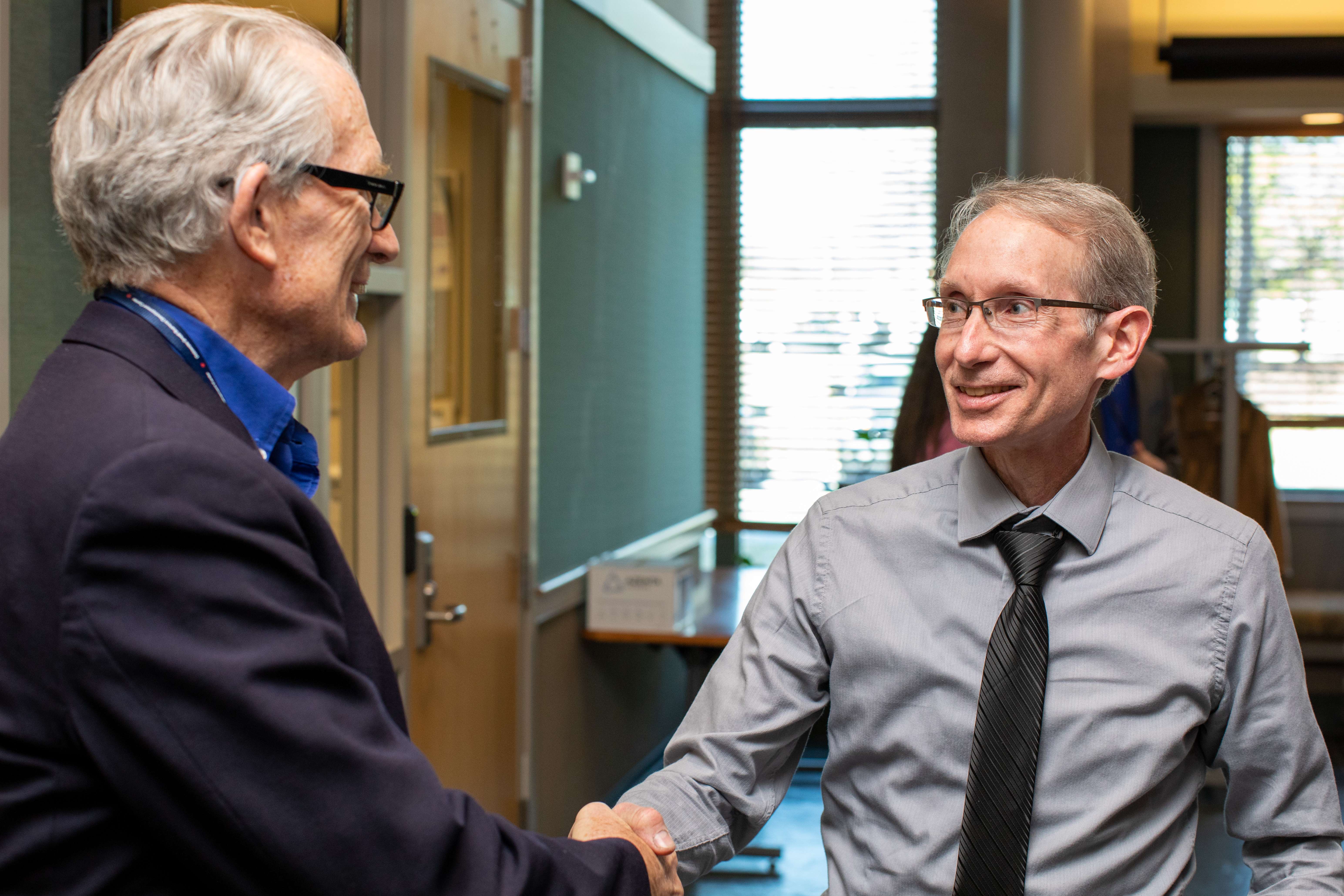 Two men in professional attire sharing a handshake