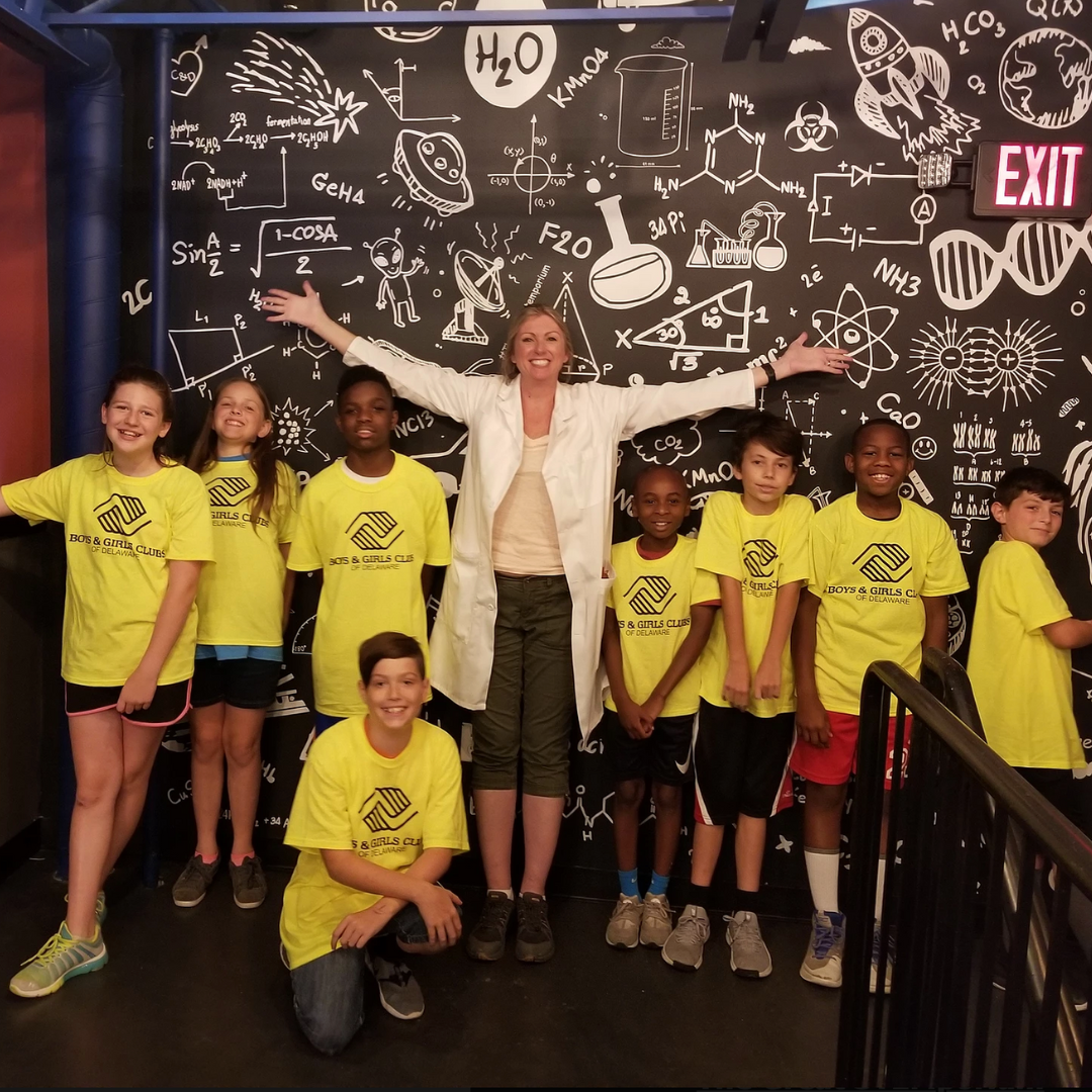 SBDC client standing with kids in yellow shirts