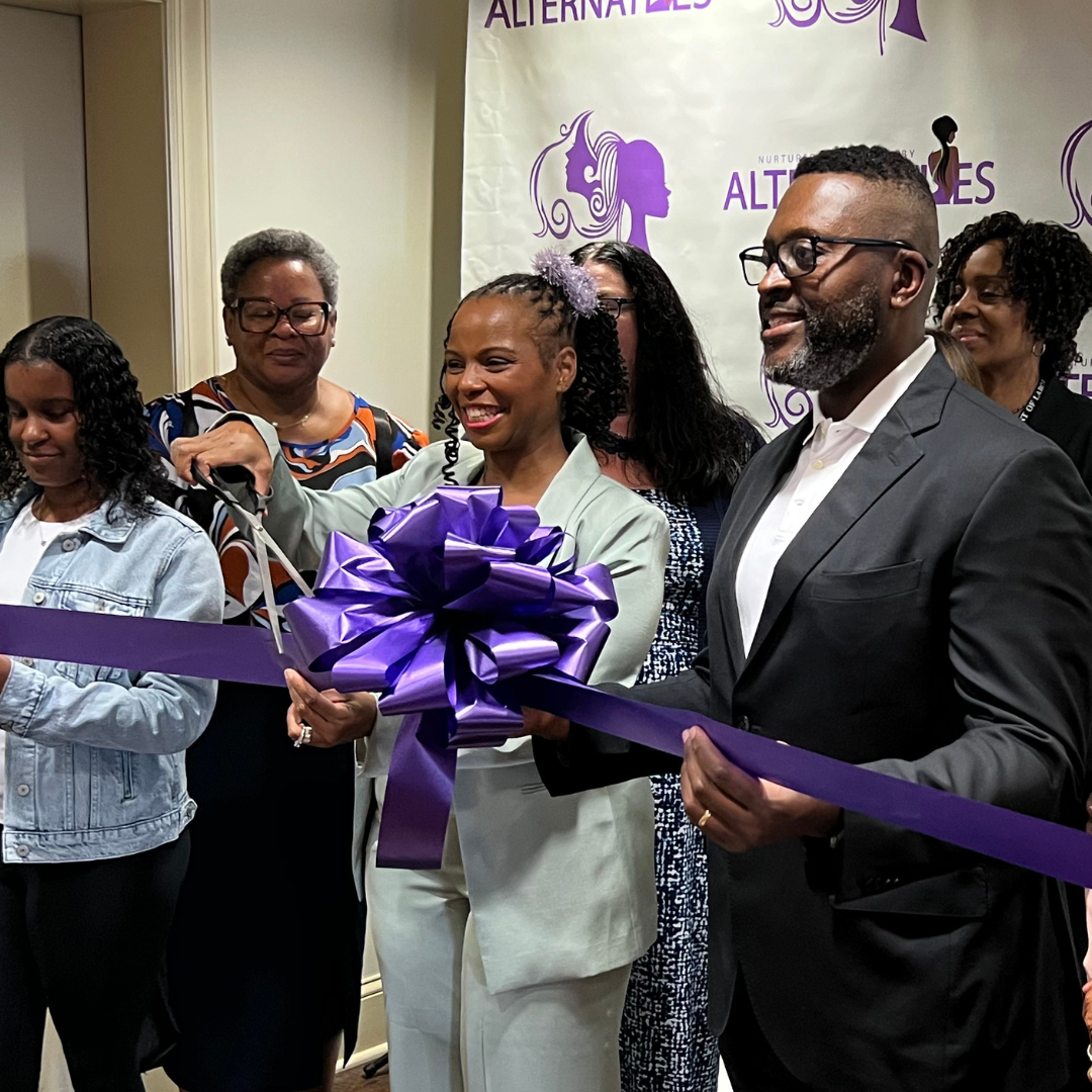 A group of people cutting a purple ribbon at a grand launch event