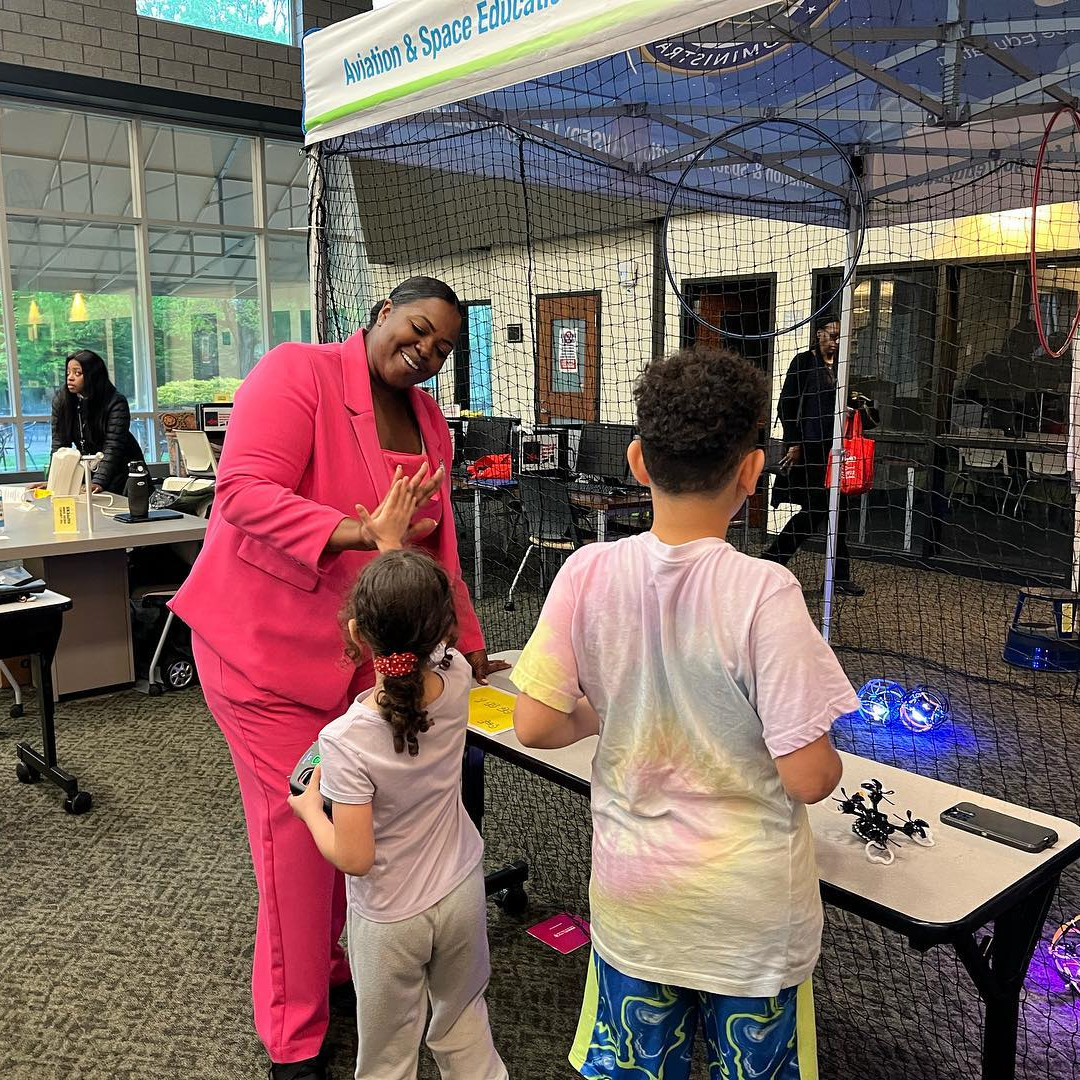 A lady in a pink suit playing with kids
