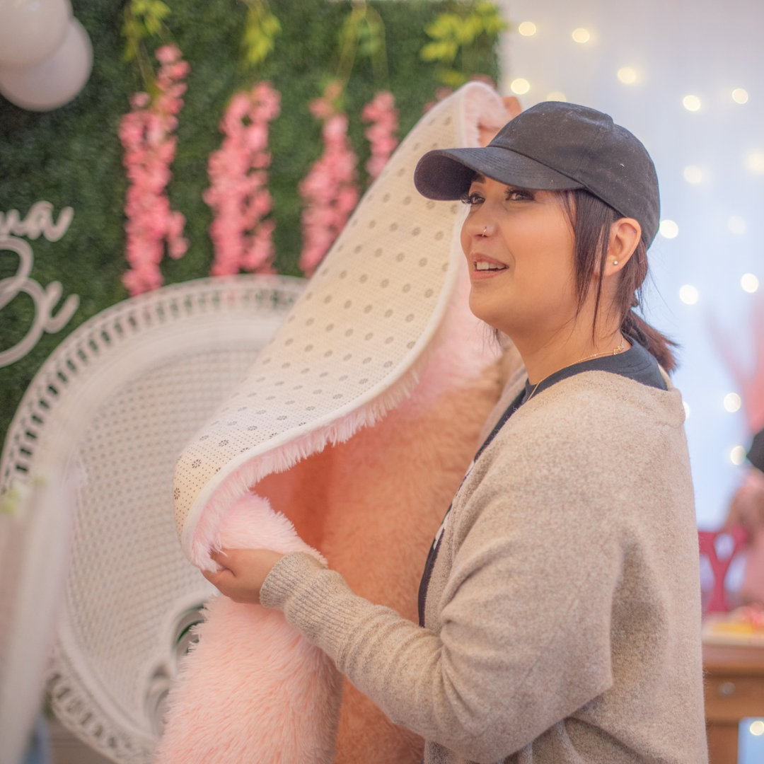 A lady holding a pink carpet at an event