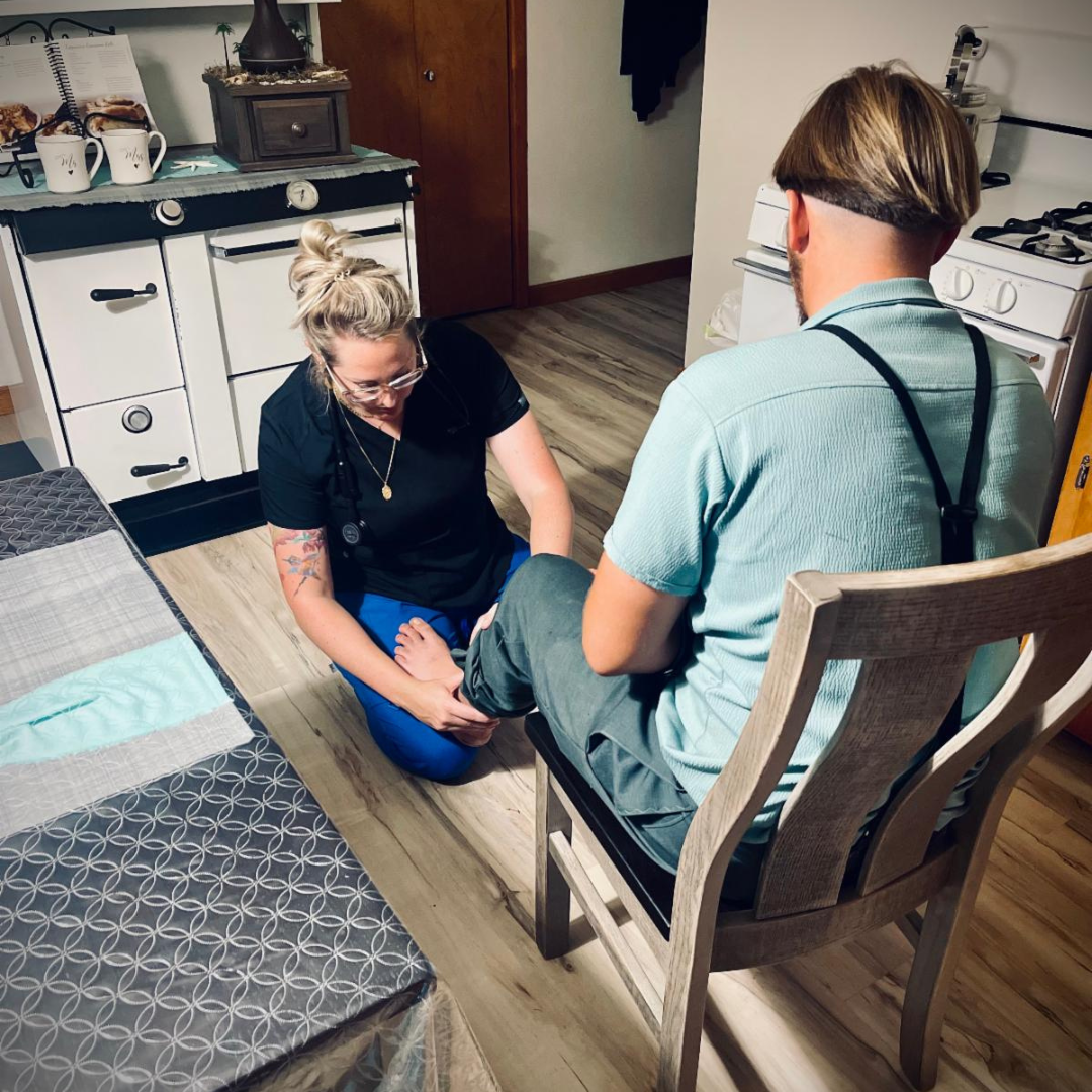 A lady massaging the feet of a client in a chair