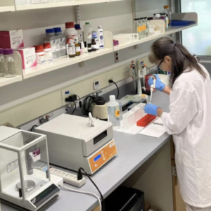 A lady wearing a lab coat and working with lab equipment
