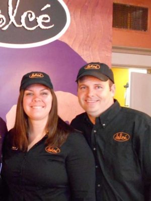 A man and a woman wearing black shirts and black caps