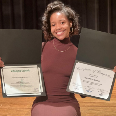 Delaware SBDC Client LiveIt Up black woman displaying two certificates.